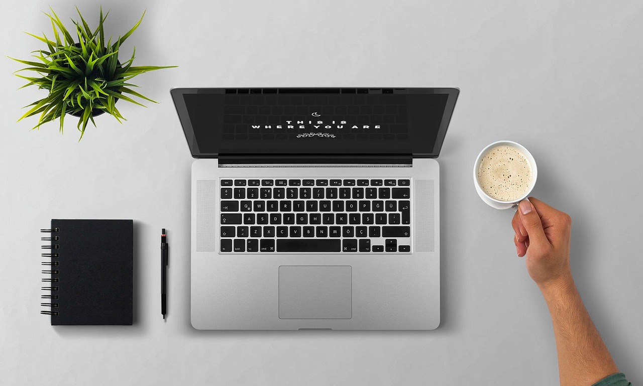 Laptop, coffee, arm — Understand Crypto Volatility Now